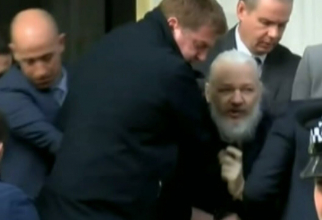 Captură YouTube - Momentul în care Julian Assange, cu părul lung și barbă, este arestat și scos din ambasada Ecuadorului la Londra, după ce a locuit acolo 7 ani