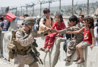 Un soldat american, jucându-se cu câțiva copii afgani în timpul misiunilor de evacuare de pe aeroportul din Kabul. Sursă foto: U.S. Department of Defense (DoD)