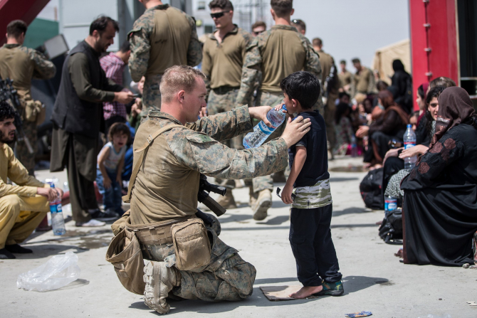 Un soldat american, oferind asistență unui copil în timpul haosului de pe aeroportul din Kabul. Sursă foto: U.S. Department of Defense (DoD)