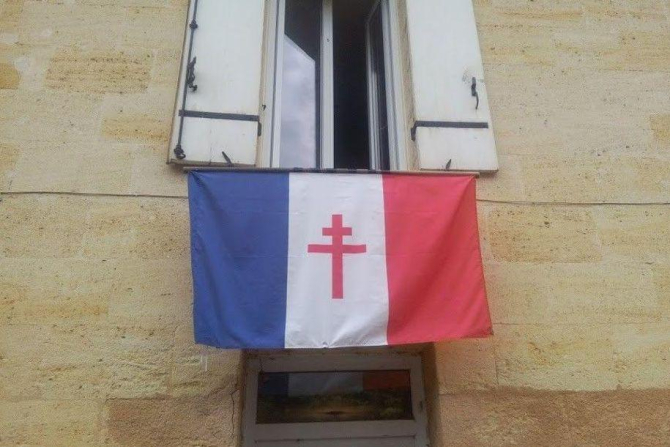 Un drapel francez cu o cruce de Lorena, simbol al Rezistenței, atârnat la o fereastră. Fotografia a fost trimisă publicației Le Figaro de către un cetățean francez din Sainte-Terre. Sursă foto: Le Figaro